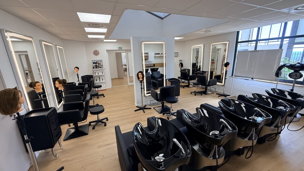 Salon pédagogique de coiffure du CFA Le Studio à Grasse Campus, avec postes de coiffage et bacs à shampooing
